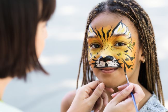 Enfant maquillé en tigre pendant une animation maquillage.